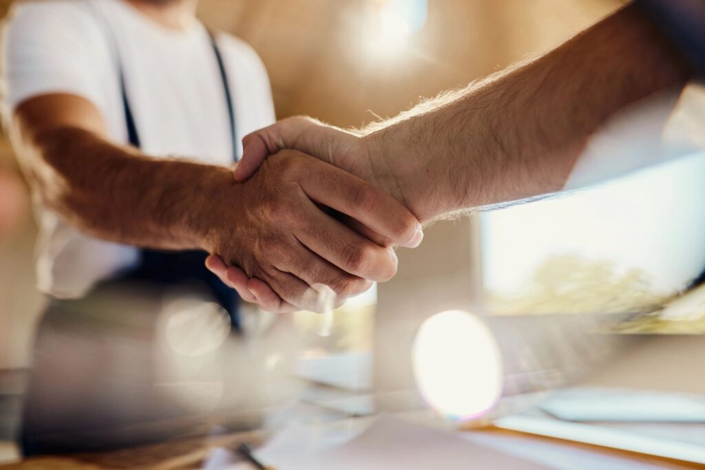 Two professionals shaking hands to confirm an agreement